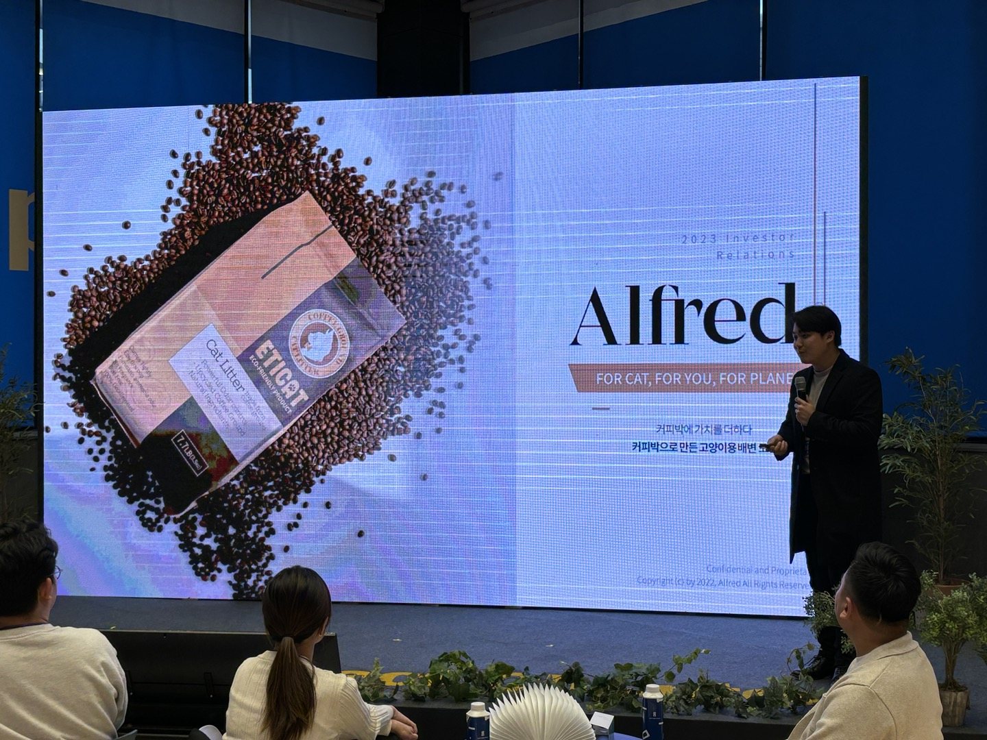 대형 LED 화면에 Alfred 로고와 2023 Investor Relations 문구가 뜬 무대에서 발표하는 권순우 대표